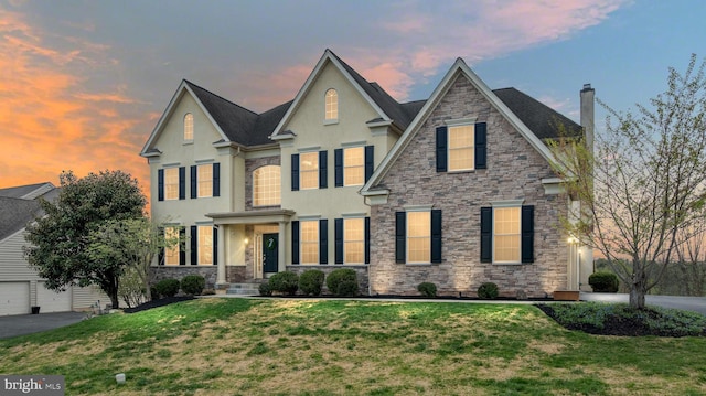 view of front of home with a lawn, stucco siding, a chimney, and stone siding