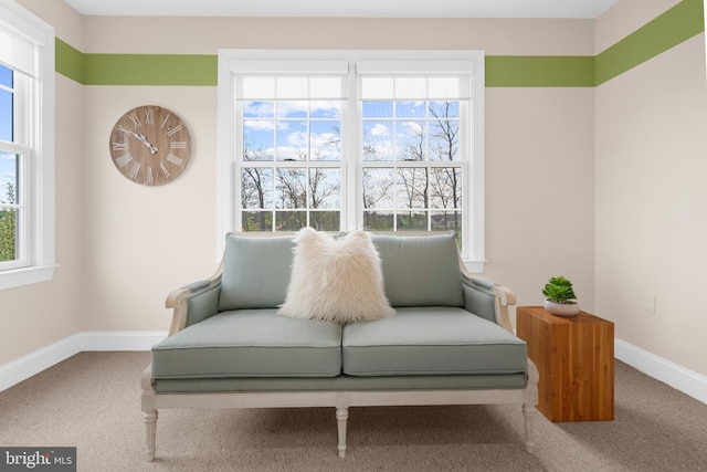 living area with baseboards, plenty of natural light, and carpet flooring