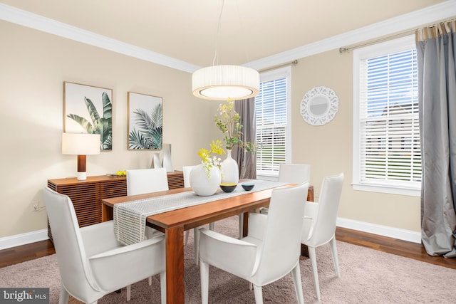 dining area with crown molding, baseboards, and wood finished floors