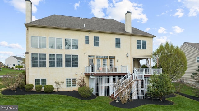 rear view of property featuring stairs, stucco siding, and a chimney