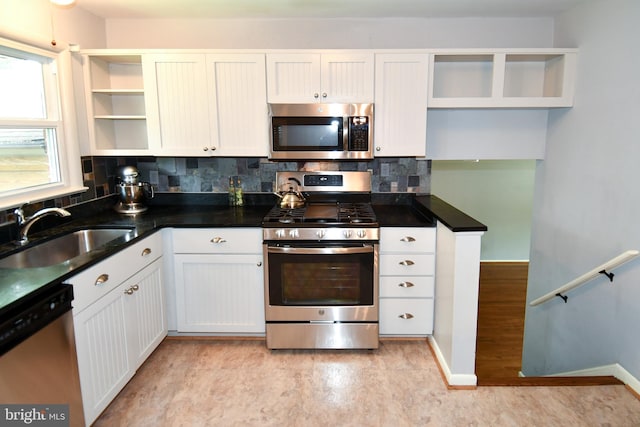 8916 Battery Rd, Alexandria, VA 22308 - kitchen with open shelves, stainless steel appliances, a sink, tasteful backsplash, and white cabinetry