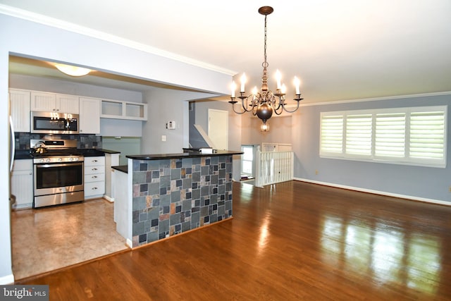 8916 Battery Rd, Alexandria, VA 22308 - kitchen with appliances with stainless steel finishes, a chandelier, ornamental molding, white cabinetry, and dark countertops