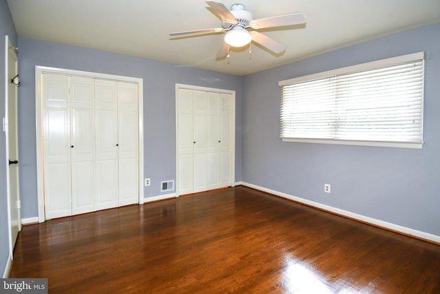 8916 Battery Rd, Alexandria, VA 22308 - unfurnished bedroom with multiple closets, wood finished floors, baseboards, and a ceiling fan