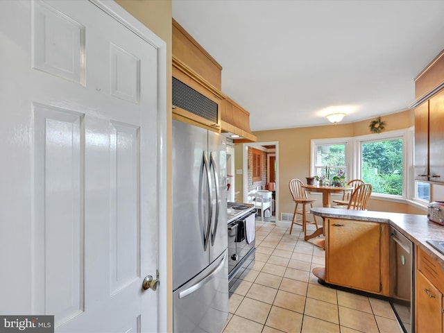24 Keeler Ave, Stevens, PA 17578 - kitchen featuring appliances with stainless steel finishes, light tile patterned floors, and brown cabinetry