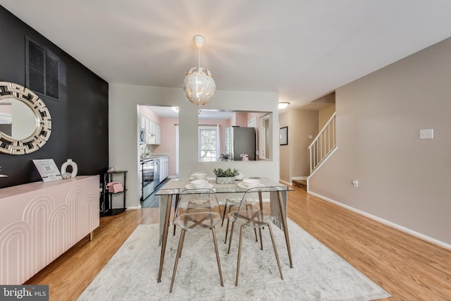 11378 Cromwell Ct, Woodbridge, VA 22192 - dining space with stairway, a notable chandelier, visible vents, light wood-style flooring, and baseboards