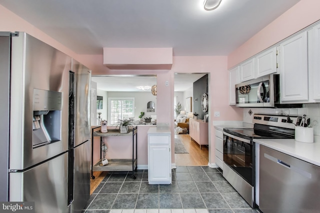 11378 Cromwell Ct, Woodbridge, VA 22192 - kitchen with tasteful backsplash, white cabinetry, light countertops, dark tile patterned floors, and appliances with stainless steel finishes