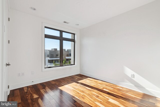 spare room featuring wood finished floors and baseboards