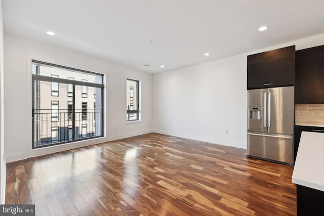 unfurnished living room with wood finished floors, baseboards, and recessed lighting