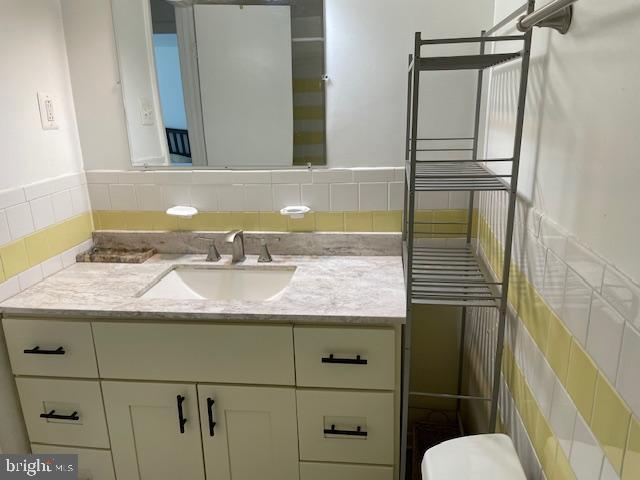 half bath featuring toilet, radiator, and vanity