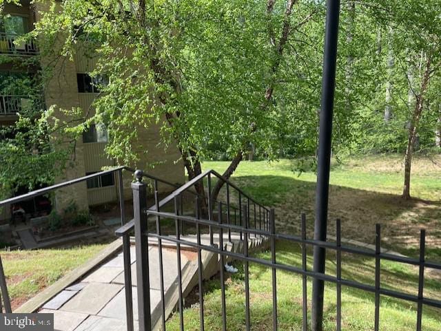 view of property's community featuring fence and a yard