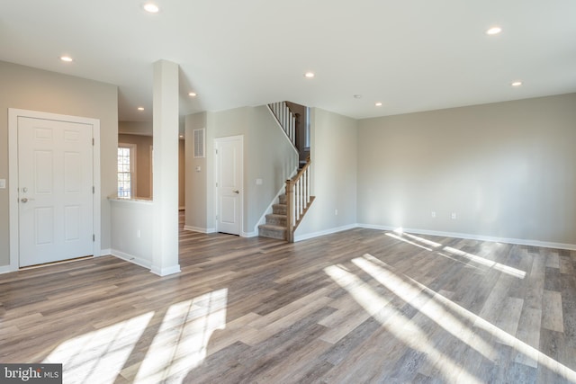 interior space with stairs, recessed lighting, baseboards, and wood finished floors