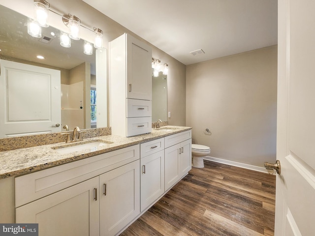 full bath with visible vents, wood finished floors, toilet, baseboards, and a sink