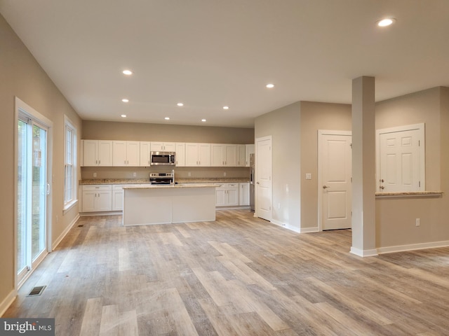 kitchen with baseboards, recessed lighting, white cabinetry, and stainless steel appliances