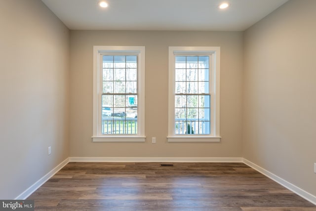 empty room with recessed lighting, baseboards, and dark wood-style floors