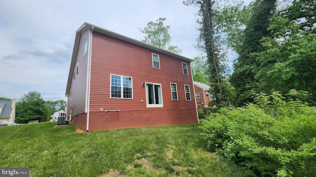 back of house featuring a lawn and central AC unit