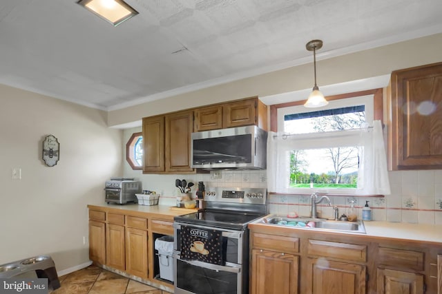 kitchen featuring decorative backsplash, brown cabinetry, a sink, and appliances with stainless steel finishes