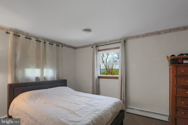 bedroom with a baseboard heating unit and visible vents