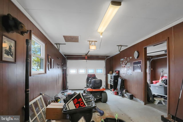 garage featuring a garage door opener and wooden walls