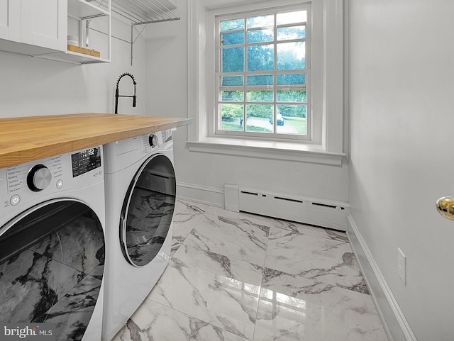 washroom with washing machine and clothes dryer, a baseboard radiator, marble look tiles, and baseboards