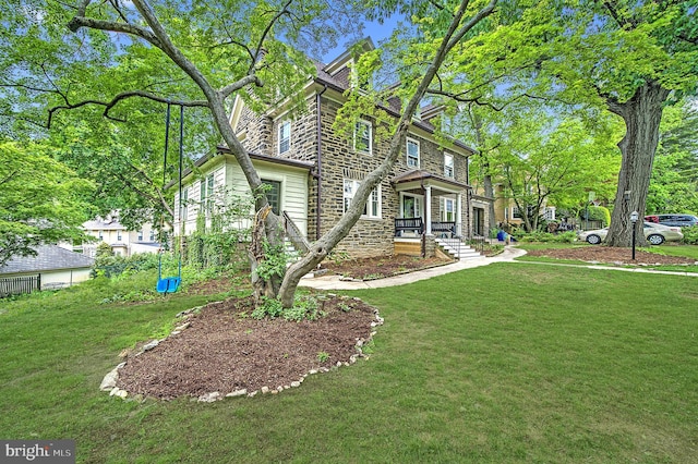 view of side of property with stone siding and a lawn