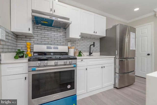 kitchen featuring stainless steel appliances, white cabinetry, light countertops, under cabinet range hood, and ornamental molding