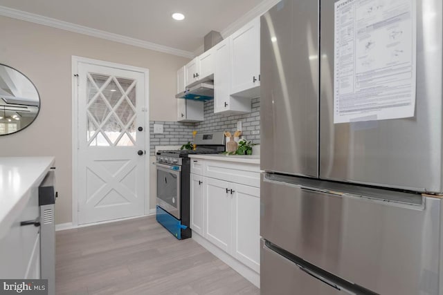 kitchen with under cabinet range hood, white cabinetry, stainless steel appliances, and light countertops