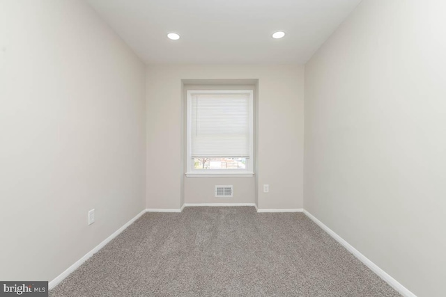 spare room with recessed lighting, carpet, visible vents, and baseboards