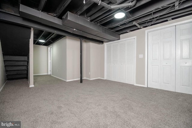 finished basement with baseboards, carpet, and stairs