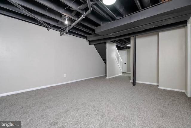 finished basement featuring carpet, stairs, and baseboards
