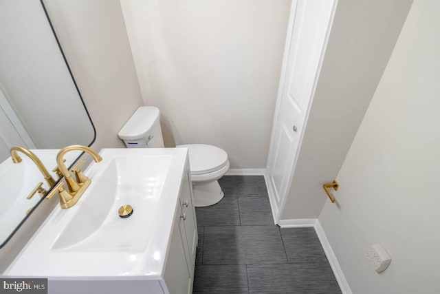 bathroom with baseboards, vanity, tile patterned floors, and toilet