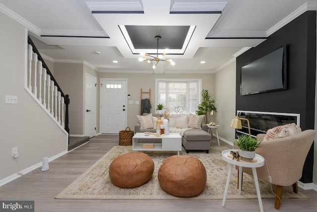 living area with a chandelier, coffered ceiling, wood finished floors, stairs, and ornamental molding