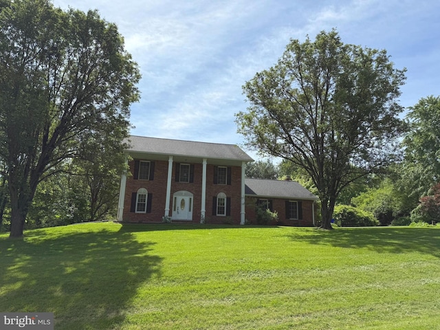 greek revival house featuring a front lawn and brick siding