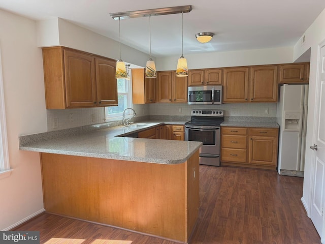 kitchen with appliances with stainless steel finishes, a sink, brown cabinetry, and decorative backsplash