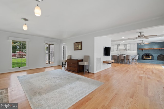 129 Kirwans Landing Ln, Chester, MD 21619 - living room featuring a fireplace, light wood-type flooring, a ceiling fan, and baseboards