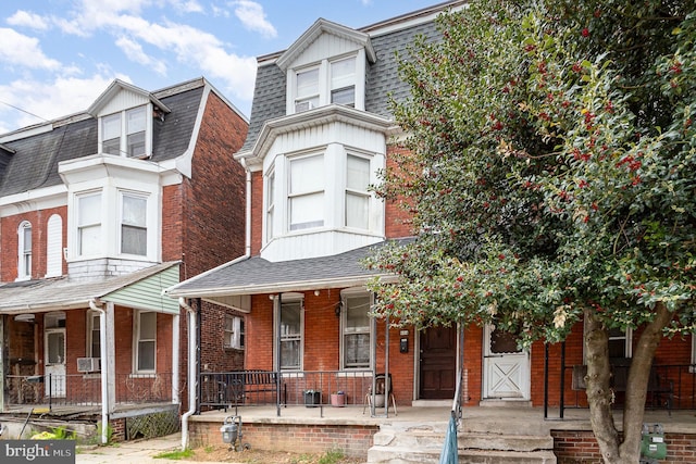804 W King St, York, PA 17403 - view of front of property with a porch, brick siding, mansard roof, cooling unit, and a shingled roof