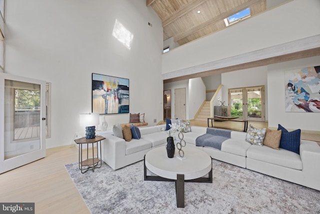 living area with wood ceiling, beamed ceiling, wood finished floors, high vaulted ceiling, and stairs