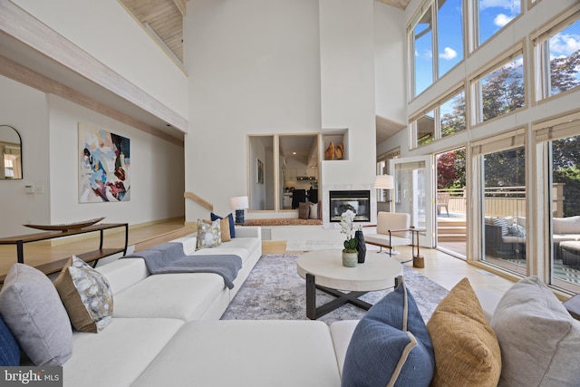 living room featuring a tile fireplace and a high ceiling