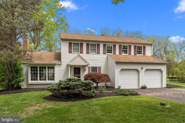 view of front of house with aphalt driveway, a garage, a front lawn, and a chimney