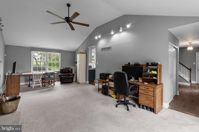 carpeted office space featuring baseboards, ceiling fan, visible vents, and vaulted ceiling