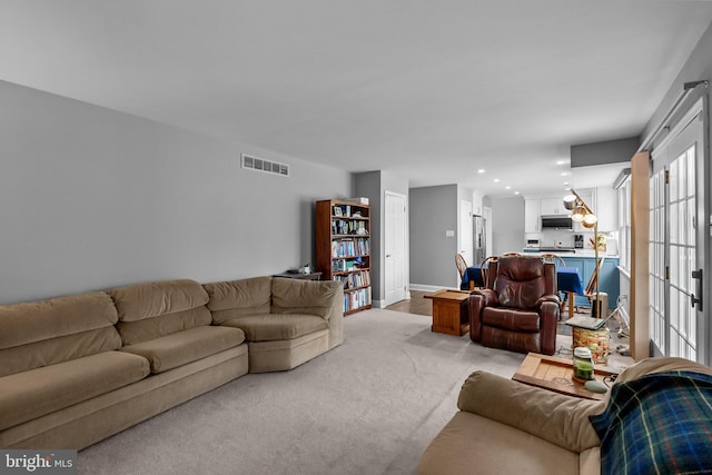 living area featuring light carpet, baseboards, visible vents, and recessed lighting
