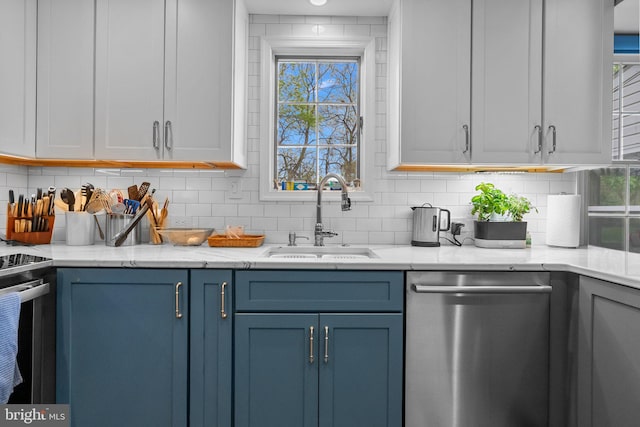 kitchen featuring a sink, range with electric cooktop, stainless steel dishwasher, backsplash, and blue cabinetry