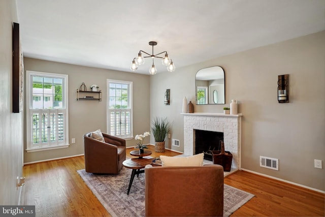living room featuring baseboards, visible vents, wood finished floors, and a fireplace