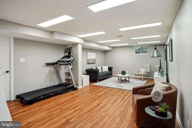 exercise area with wood finished floors and visible vents