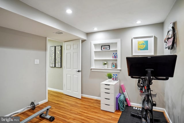 workout area featuring baseboards, recessed lighting, light wood-style flooring, and visible vents