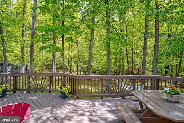 deck featuring fence and a wooded view