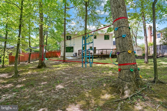 view of play area featuring fence and a wooden deck