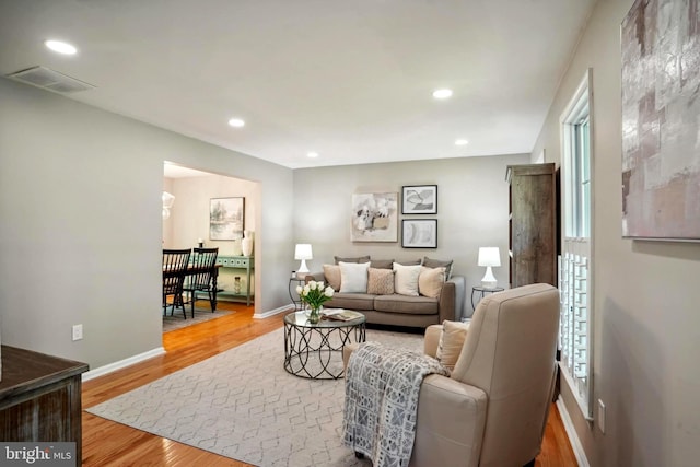 living area featuring plenty of natural light, recessed lighting, baseboards, wood finished floors, and visible vents