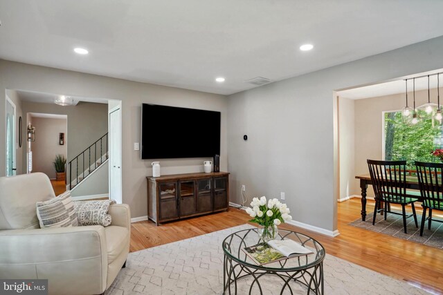 living room featuring visible vents, recessed lighting, light wood finished floors, and stairs
