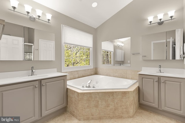 bathroom featuring lofted ceiling, a garden tub, tile patterned floors, and a sink