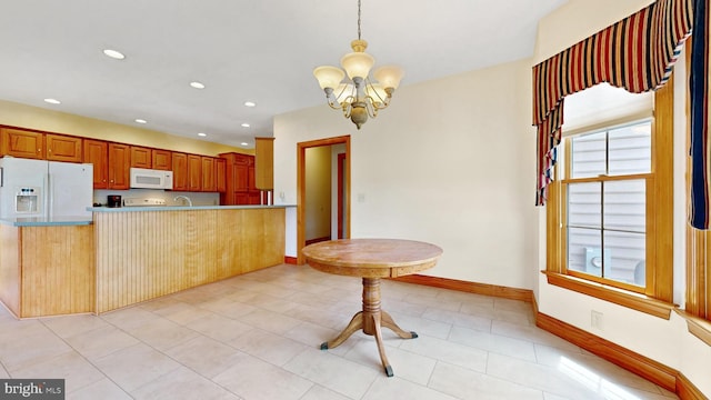 28342 Discount Land Rd, Laurel, DE 19956 - kitchen with pendant lighting, baseboards, white appliances, a notable chandelier, and a peninsula